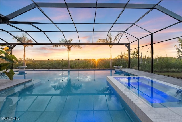 8923 Nevis Way, Naples, FL 34112 - pool at dusk with an outdoor pool, a hot tub, glass enclosure, and a patio area