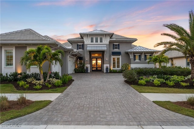 8923 Nevis Way, Naples, FL 34112 - view of front of home featuring french doors, decorative driveway, stucco siding, and a garage