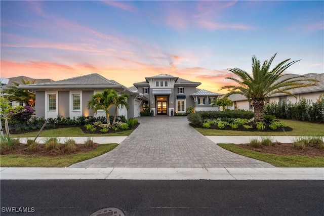 8923 Nevis Way, Naples, FL 34112 - prairie-style house with decorative driveway, a garage, french doors, and stucco siding