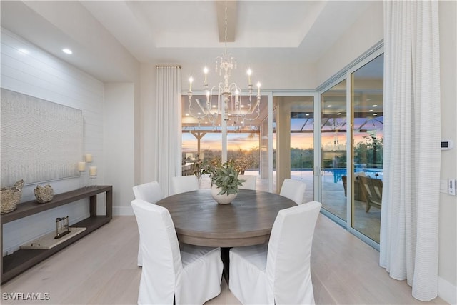 8923 Nevis Way, Naples, FL 34112 - dining space with light wood finished floors, a raised ceiling, a chandelier, and a wall of windows