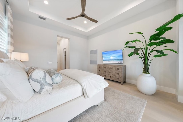 8923 Nevis Way, Naples, FL 34112 - bedroom with light wood-style floors, a tray ceiling, recessed lighting, and a ceiling fan