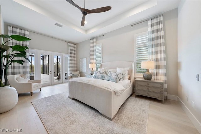 8923 Nevis Way, Naples, FL 34112 - bedroom featuring access to exterior, french doors, a raised ceiling, and light wood-style flooring
