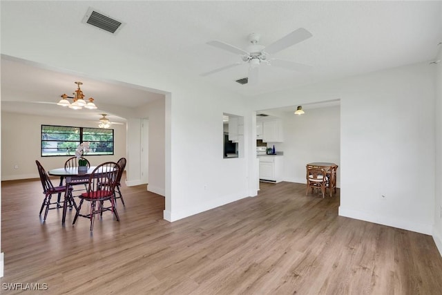 4925 Molokai Dr Unit 16, Naples, FL 34112 - dining space with light wood-style floors, a ceiling fan, and a chandelier