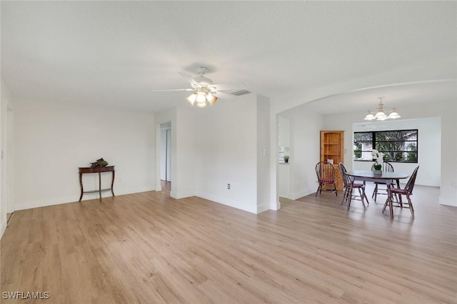 4925 Molokai Dr Unit 16, Naples, FL 34112 - living room with a chandelier, light wood-type flooring, arched walkways, and a ceiling fan