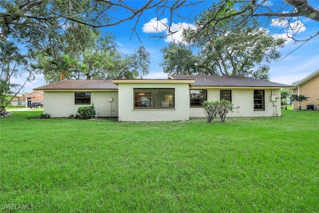 4925 Molokai Dr Unit 16, Naples, FL 34112 - rear view of house featuring stucco siding, a lawn, and a shingled roof