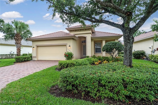 11970 Bramble Cove Dr, Fort Myers, FL 33905 - mediterranean / spanish-style house featuring stucco siding, an attached garage, decorative driveway, a tile roof, and a front yard