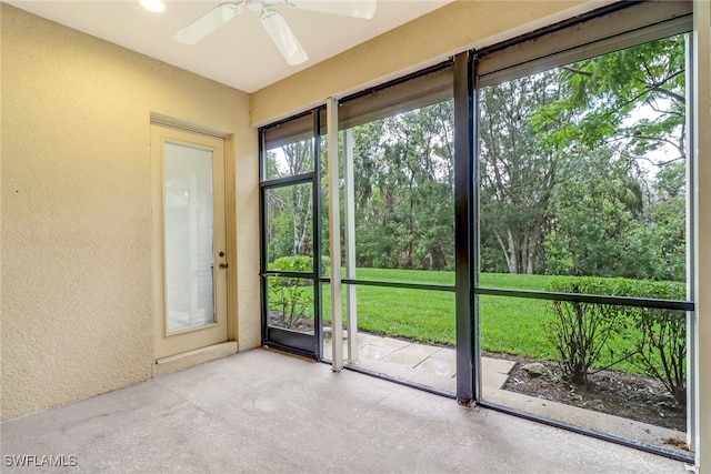 11970 Bramble Cove Dr, Fort Myers, FL 33905 - unfurnished sunroom featuring a ceiling fan, a textured wall, and concrete flooring