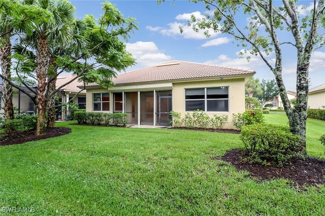11970 Bramble Cove Dr, Fort Myers, FL 33905 - rear view of house with a tiled roof, stucco siding, a lawn, and a sunroom