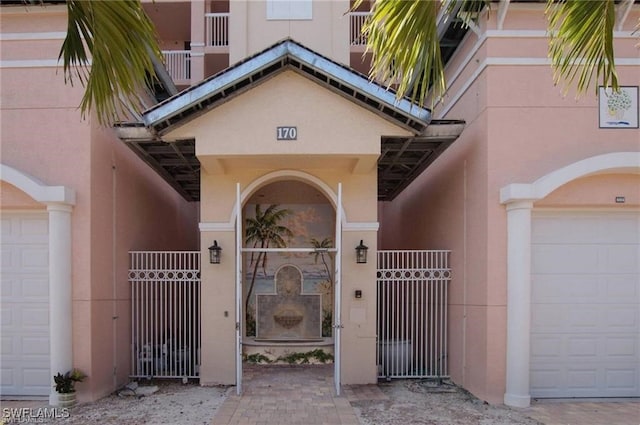 170 Lenell Rd Unit 202, Fort Myers Beach, FL 33931 - property entrance featuring a garage, stucco siding, and a gate