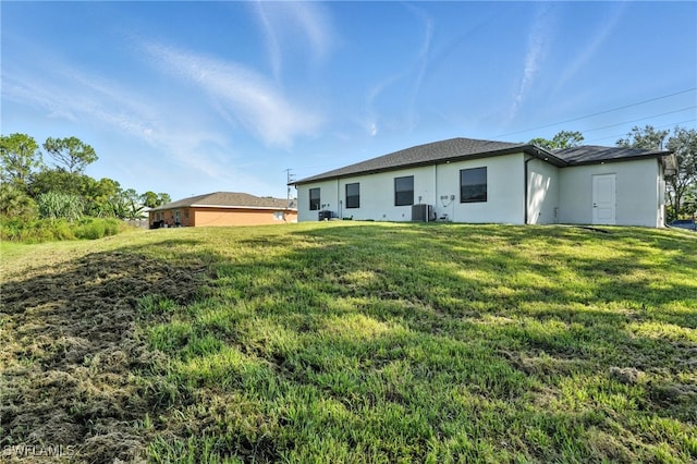 4881/4883 Leonard Blvd S, Lehigh Acres, FL 33973 - back of house featuring stucco siding and a lawn