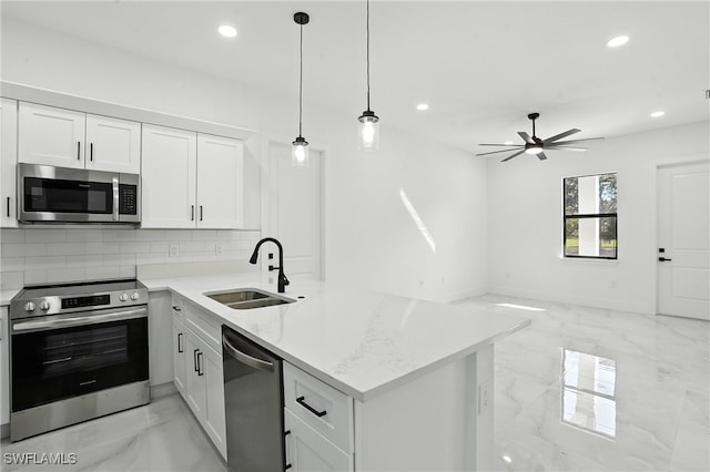 4881/4883 Leonard Blvd S, Lehigh Acres, FL 33973 - kitchen with appliances with stainless steel finishes, light marble finish floors, a peninsula, recessed lighting, and a ceiling fan