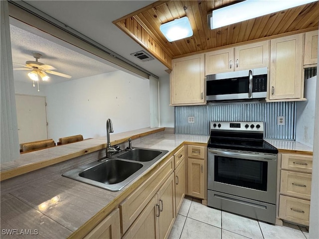 1069 Villa Dr Unit B103, Labelle, FL 33935 - kitchen featuring appliances with stainless steel finishes, light tile patterned flooring, wooden ceiling, ceiling fan, and a peninsula