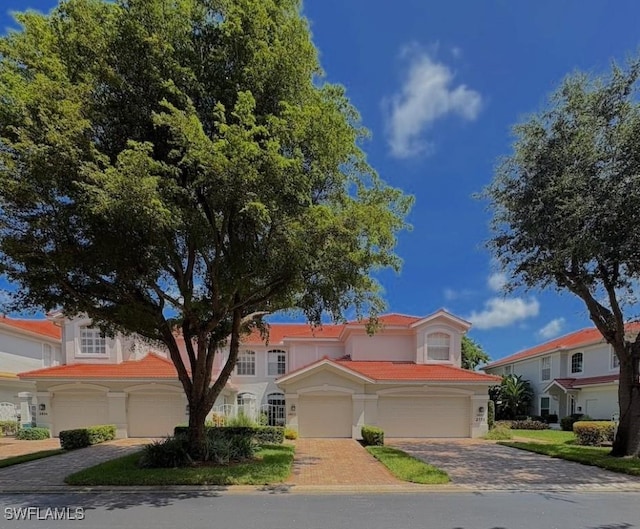2115 Arielle Dr Unit 2602, Naples, FL 34109 - mediterranean / spanish house featuring decorative driveway, a tiled roof, and an attached garage