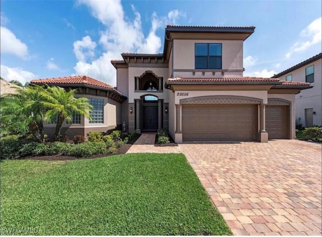 23056 Sanabria Loop, Bonita Springs, FL 34135 - mediterranean / spanish-style house featuring decorative driveway, stucco siding, a front lawn, and a tile roof