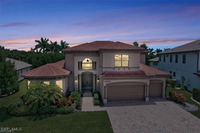 23056 Sanabria Loop, Bonita Springs, FL 34135 - mediterranean / spanish-style home featuring driveway, a tile roof, stucco siding, and a lawn