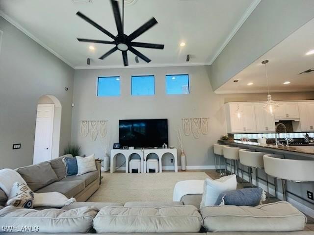 23056 Sanabria Loop, Bonita Springs, FL 34135 - living area with ceiling fan, crown molding, arched walkways, a high ceiling, and recessed lighting