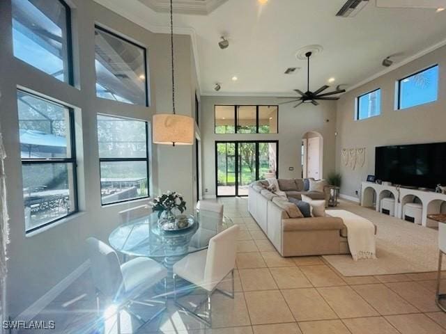 23056 Sanabria Loop, Bonita Springs, FL 34135 - living room featuring crown molding, a towering ceiling, light tile patterned floors, ceiling fan, and arched walkways