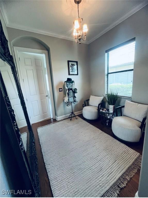 23056 Sanabria Loop, Bonita Springs, FL 34135 - living area featuring wood finished floors, crown molding, and a chandelier