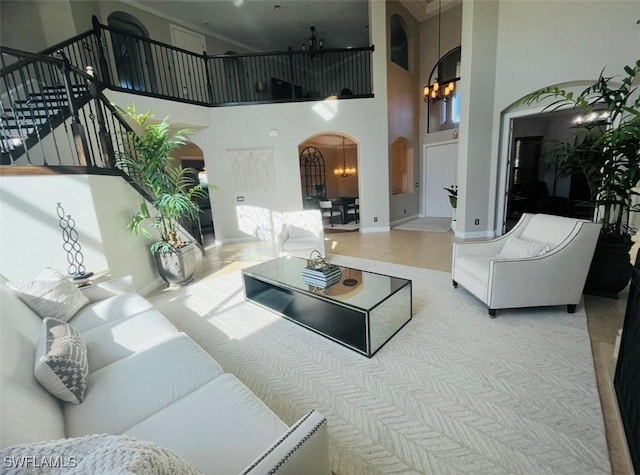 23056 Sanabria Loop, Bonita Springs, FL 34135 - living area with arched walkways, a towering ceiling, stairway, and ornamental molding
