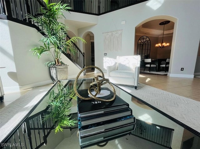 23056 Sanabria Loop, Bonita Springs, FL 34135 - stairs with arched walkways, tile patterned flooring, a chandelier, a towering ceiling, and a tray ceiling