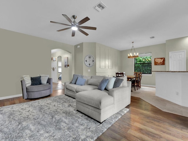 446 SW 19th Ter, Cape Coral, FL 33991 - living room featuring arched walkways, ceiling fan, wood finished floors, and a chandelier