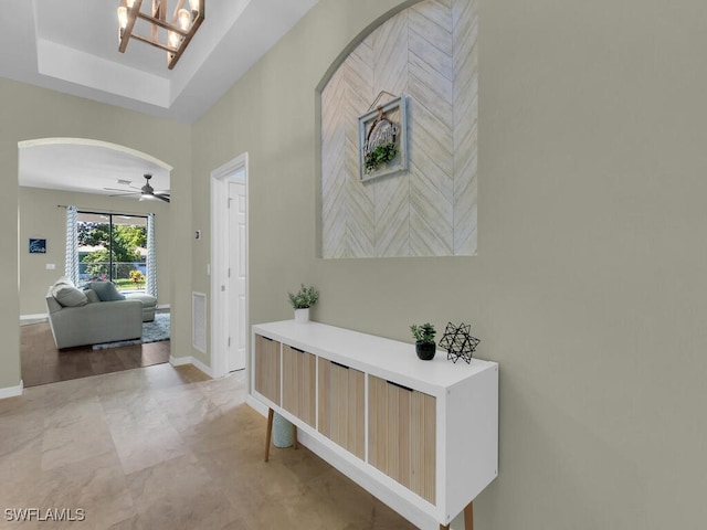446 SW 19th Ter, Cape Coral, FL 33991 - hall with arched walkways, a tray ceiling, and a chandelier
