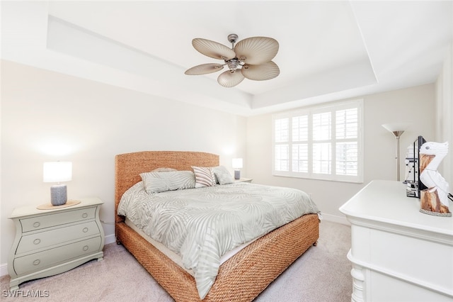1128 Manor Lake Dr Unit G103, Naples, FL 34110 - bedroom with light colored carpet, a raised ceiling, and a ceiling fan