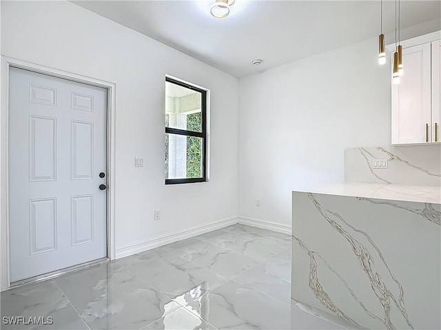 3705 8th St SW, Lehigh Acres, FL 33976 - unfurnished dining area with light marble finish floors and baseboards