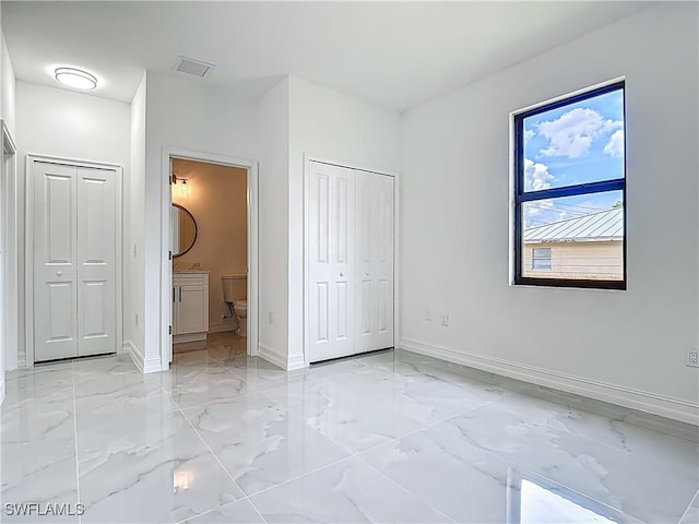 3705 8th St SW, Lehigh Acres, FL 33976 - unfurnished bedroom featuring light marble finish floors and ensuite bath