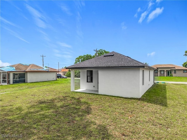 3705 8th St SW, Lehigh Acres, FL 33976 - rear view of property with roof with shingles, a lawn, and stucco siding