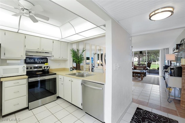 1086 Forest Lakes Dr Unit 9106, Naples, FL 34105 - kitchen with appliances with stainless steel finishes, under cabinet range hood, light tile patterned floors, light countertops, and ceiling fan