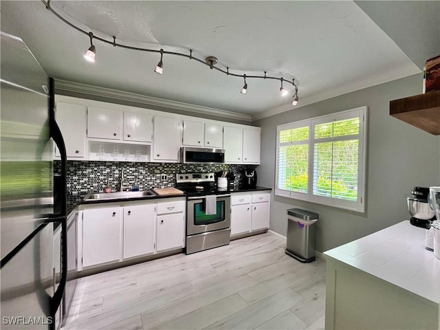 34 Glades Blvd Unit 1461, Naples, FL 34112 - kitchen with stainless steel appliances, crown molding, decorative backsplash, white cabinets, and dark countertops