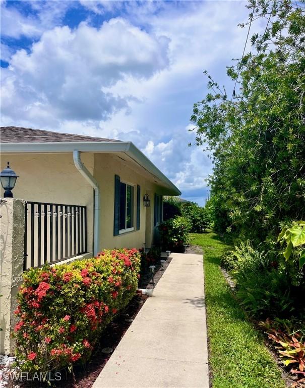 34 Glades Blvd Unit 1461, Naples, FL 34112 - view of side of home with stucco siding and a shingled roof