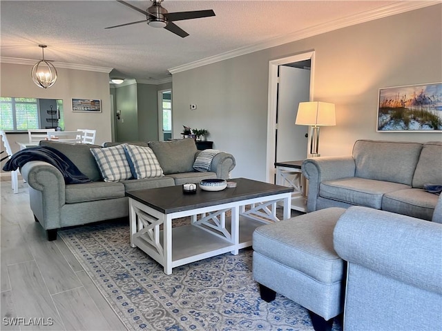 34 Glades Blvd Unit 1461, Naples, FL 34112 - living room featuring a ceiling fan, crown molding, a chandelier, and a textured ceiling