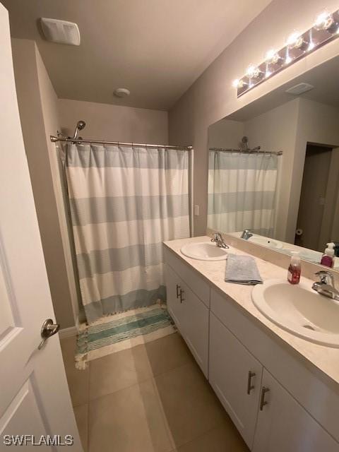 18521 Cronin Sand Ln, North Fort Myers, FL 33917 - bathroom with double vanity, tile patterned flooring, and curtained shower