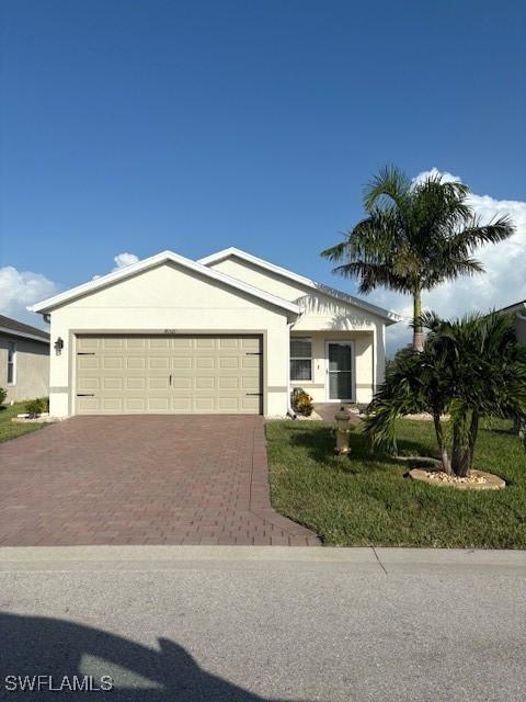 18521 Cronin Sand Ln, North Fort Myers, FL 33917 - ranch-style house with decorative driveway, a garage, stucco siding, and a front lawn