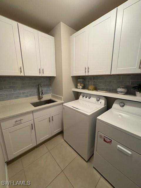 18521 Cronin Sand Ln, North Fort Myers, FL 33917 - washroom with washing machine and dryer, cabinet space, and light tile patterned flooring