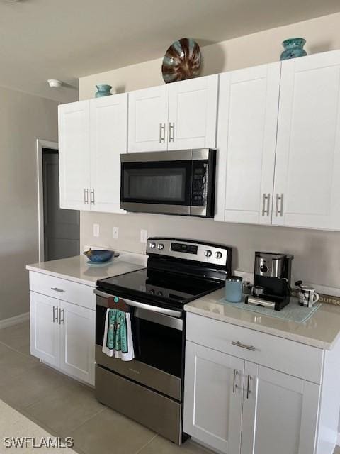 18521 Cronin Sand Ln, North Fort Myers, FL 33917 - kitchen featuring appliances with stainless steel finishes, light tile patterned floors, light countertops, and white cabinetry