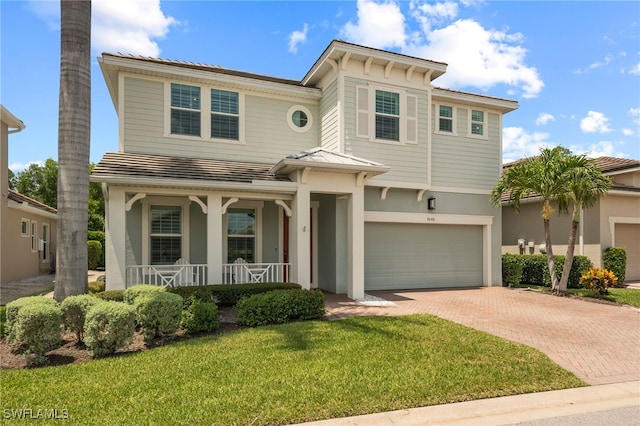 3640 Pilot Cir, Naples, FL 34120 - view of front of house with decorative driveway, a porch, stucco siding, an attached garage, and a front yard