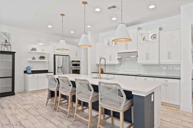 3640 Pilot Cir, Naples, FL 34120 - kitchen featuring exhaust hood, stainless steel appliances, open shelves, tasteful backsplash, and white cabinetry