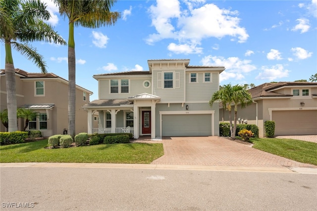 3640 Pilot Cir, Naples, FL 34120 - mediterranean / spanish house featuring a porch, decorative driveway, a front yard, stucco siding, and an attached garage