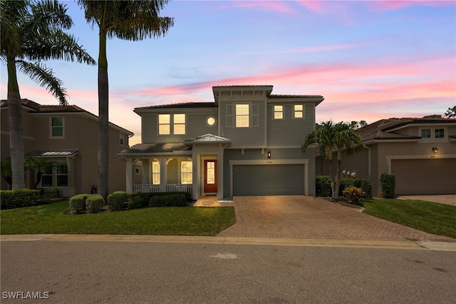 3640 Pilot Cir, Naples, FL 34120 - view of front facade with decorative driveway, a porch, a lawn, and a garage