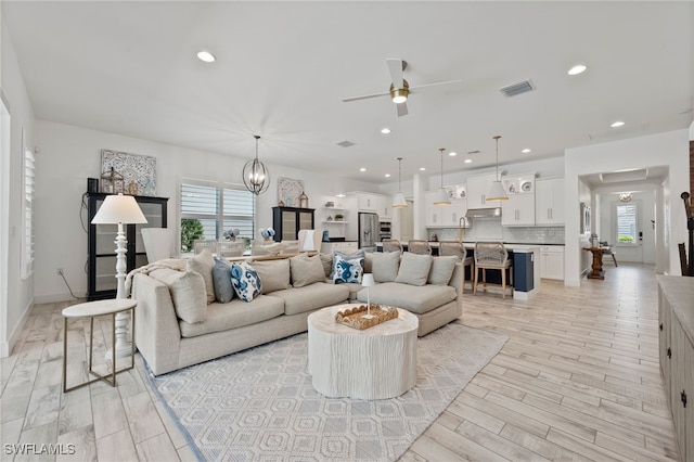 3640 Pilot Cir, Naples, FL 34120 - living room with ceiling fan, a chandelier, light wood-type flooring, and recessed lighting