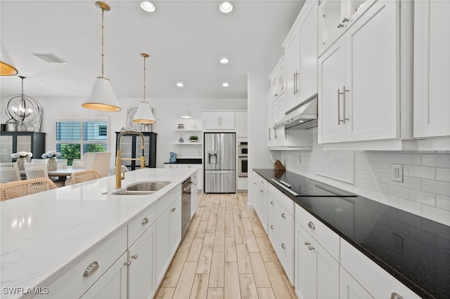3640 Pilot Cir, Naples, FL 34120 - kitchen featuring appliances with stainless steel finishes, under cabinet range hood, white cabinets, a chandelier, and recessed lighting