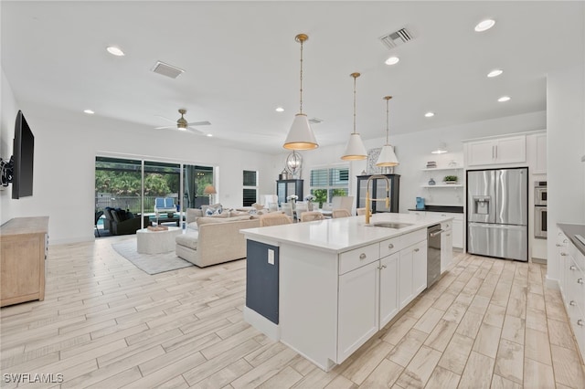 3640 Pilot Cir, Naples, FL 34120 - kitchen featuring appliances with stainless steel finishes, ceiling fan, light wood-style flooring, a center island with sink, and recessed lighting