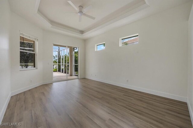 1087 Port Orange Way, Naples, FL 34120 - spare room featuring a tray ceiling, wood finished floors, and a ceiling fan