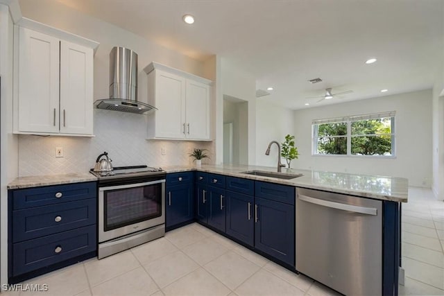 1087 Port Orange Way, Naples, FL 34120 - kitchen with stainless steel appliances, wall chimney range hood, a peninsula, white cabinets, and blue cabinets