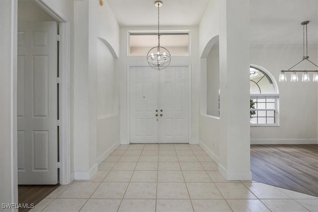1087 Port Orange Way, Naples, FL 34120 - foyer entrance featuring a chandelier, light tile patterned floors, and arched walkways