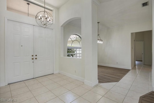 1087 Port Orange Way, Naples, FL 34120 - foyer entrance with a chandelier, light tile patterned flooring, and arched walkways