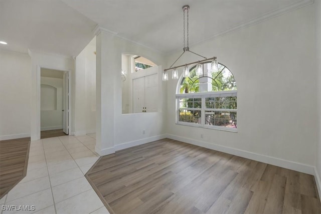 1087 Port Orange Way, Naples, FL 34120 - unfurnished dining area with crown molding, tile patterned floors, arched walkways, and recessed lighting